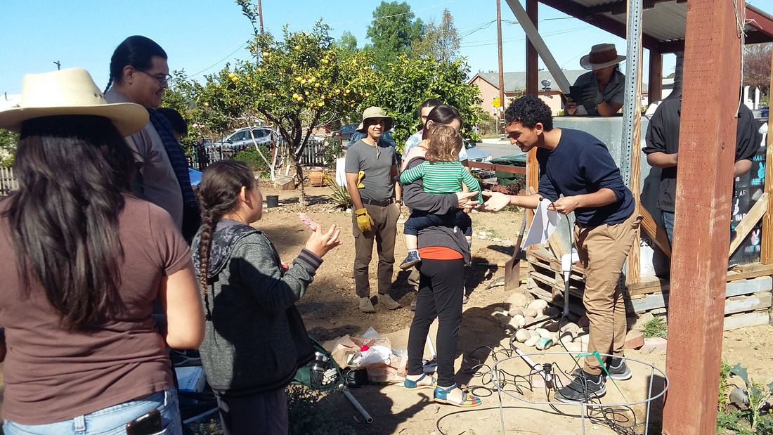 Team member explaining to group of participants about testing the irrigation prototype